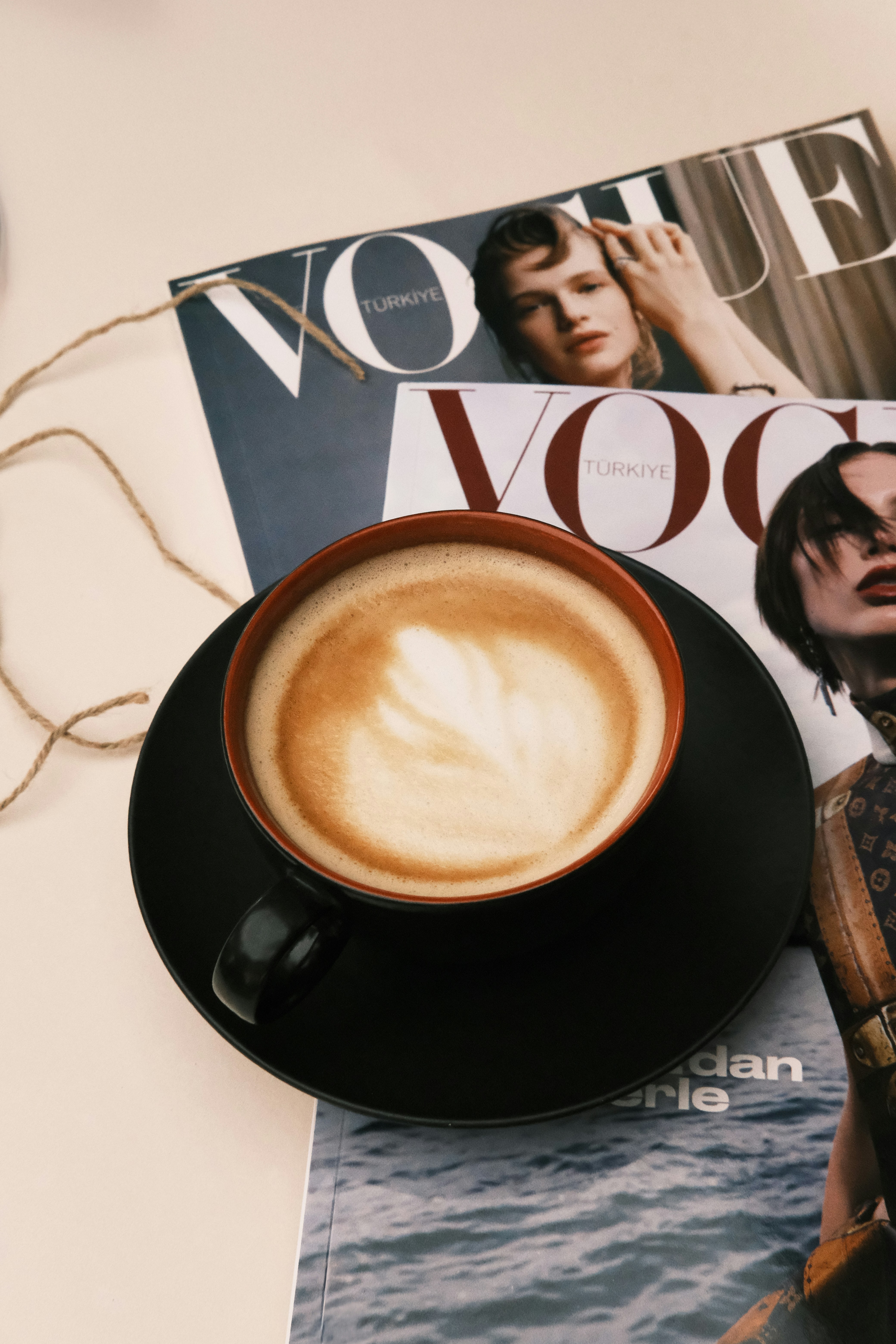 A cup of coffee sitting on top of a magazine