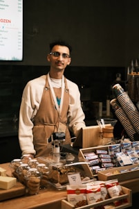 A man standing behind a counter filled with food