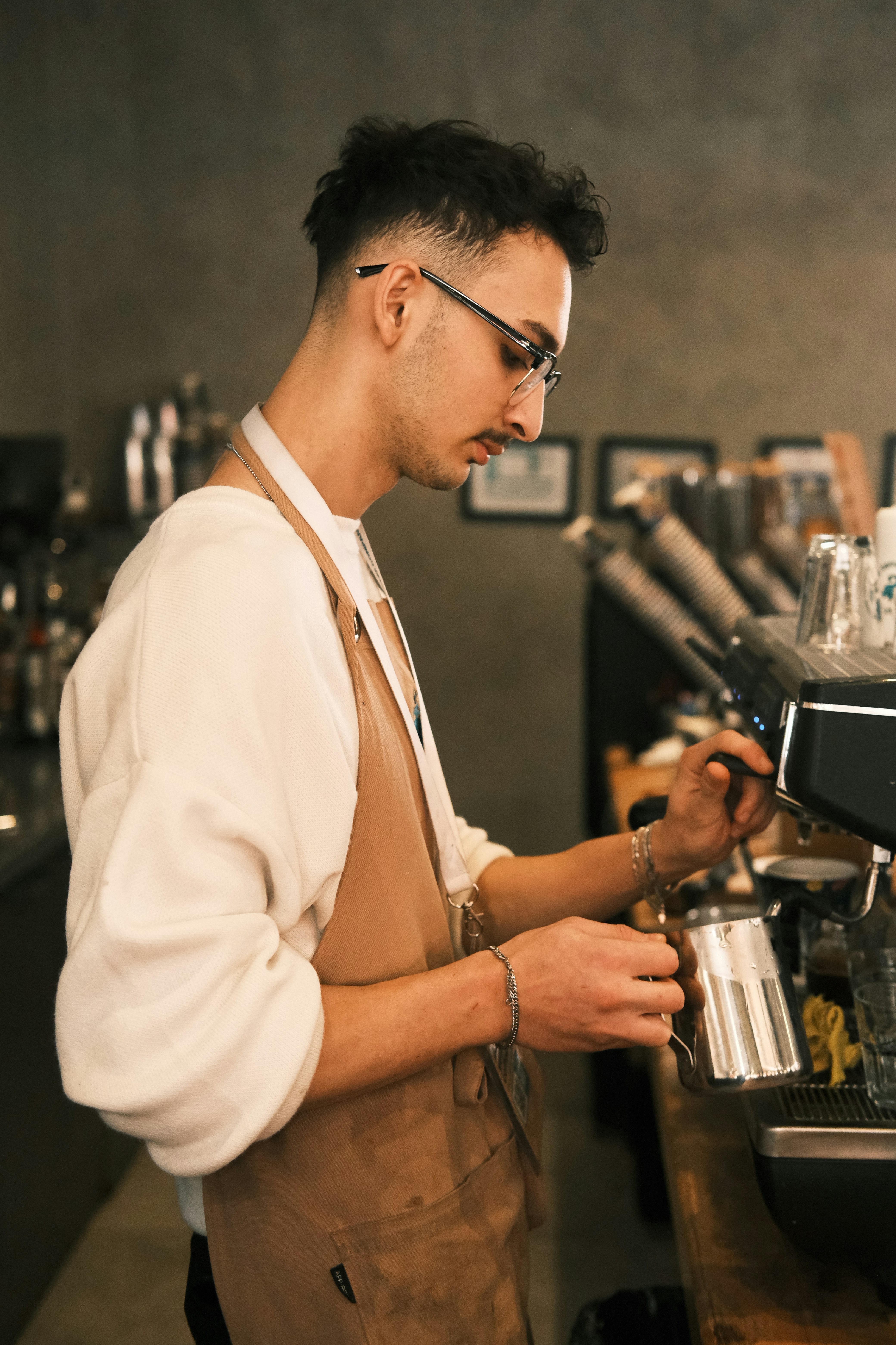 A man standing at a bar pouring a cup of coffee