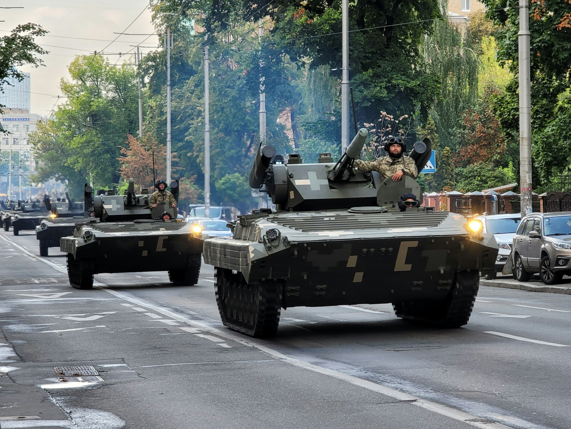 A group of tanks driving down a street