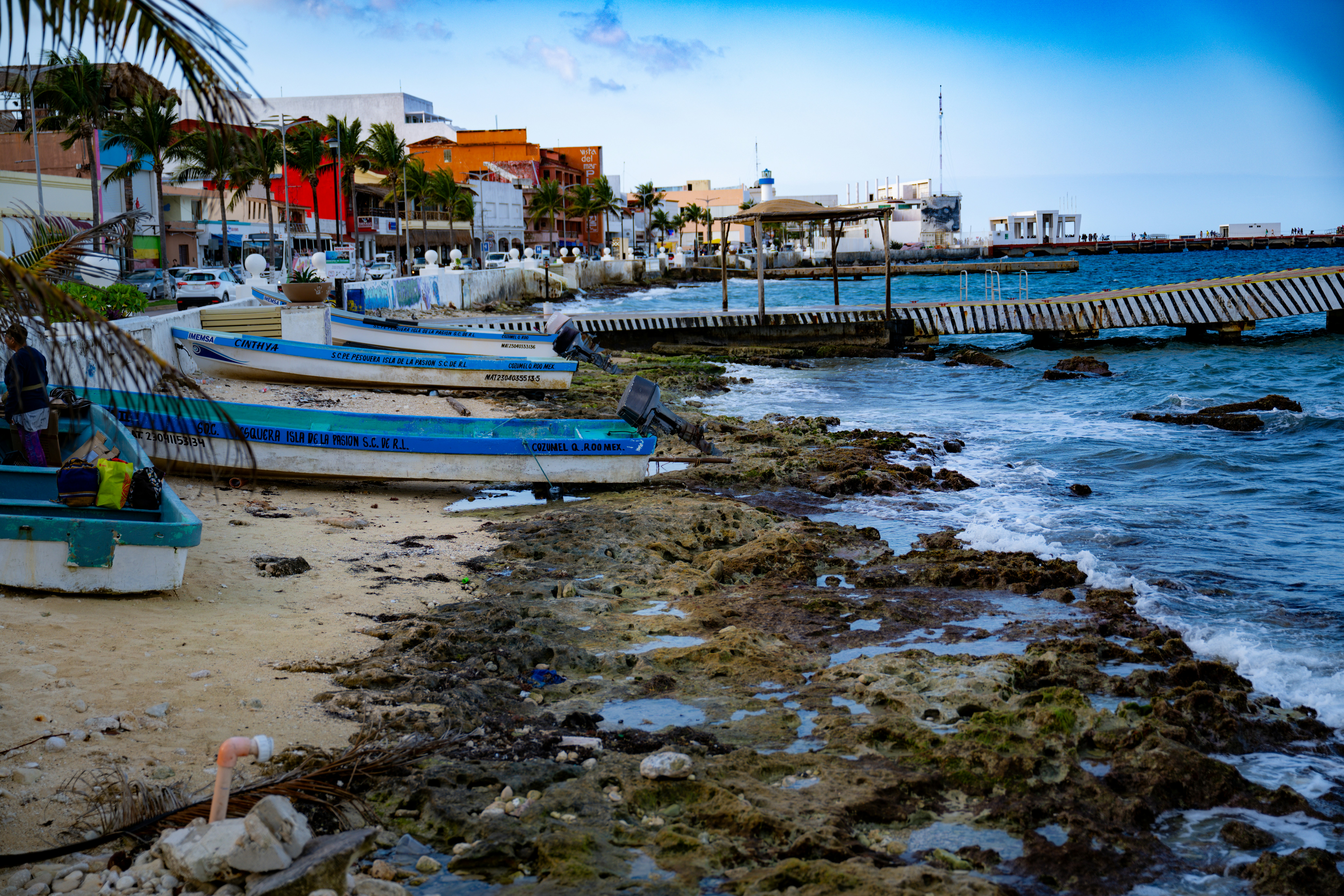 A group of boats sitting on top of a beach next to the ocean