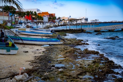A group of boats sitting on top of a beach next to the ocean