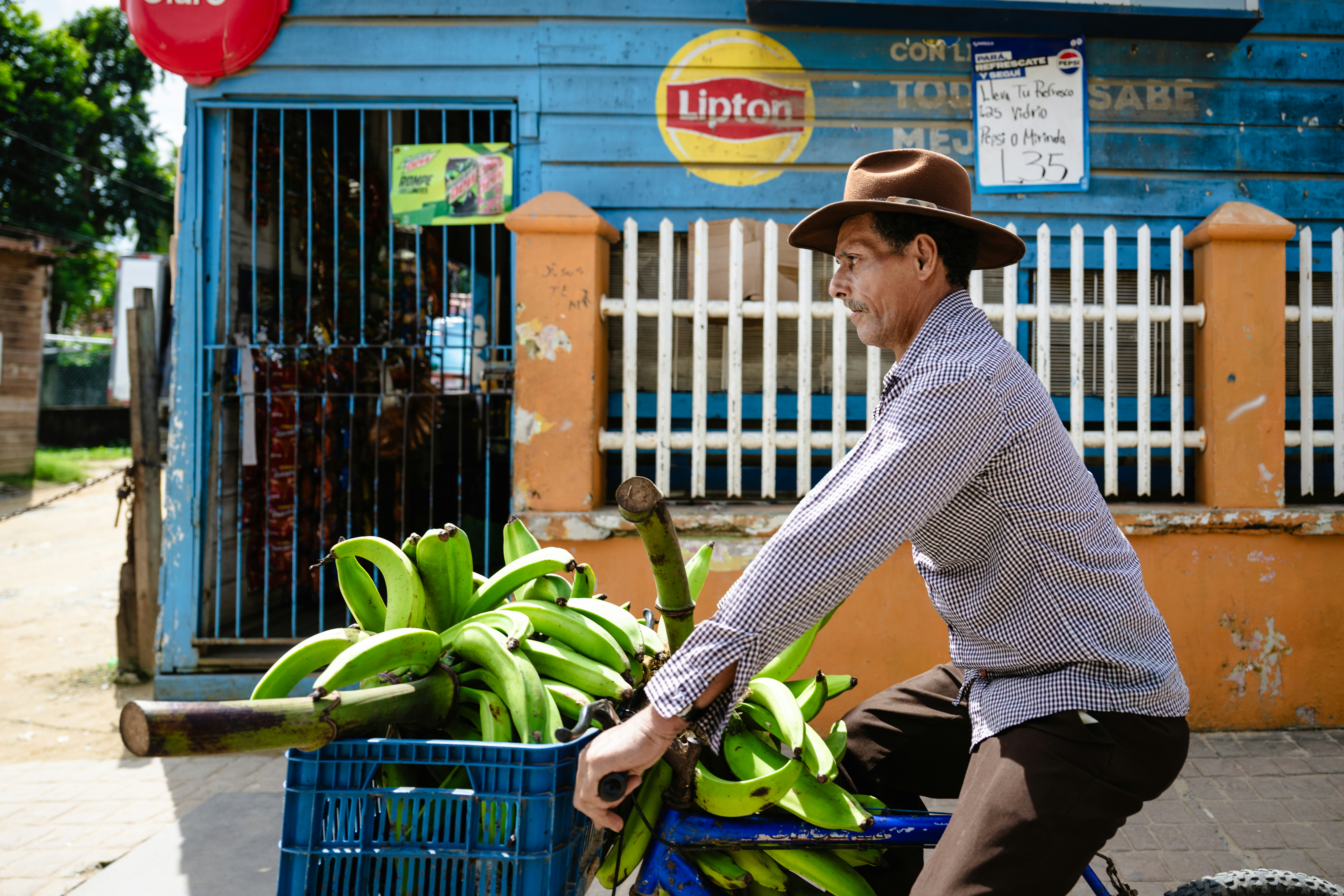 A man riding a bike with a basket full of bananas