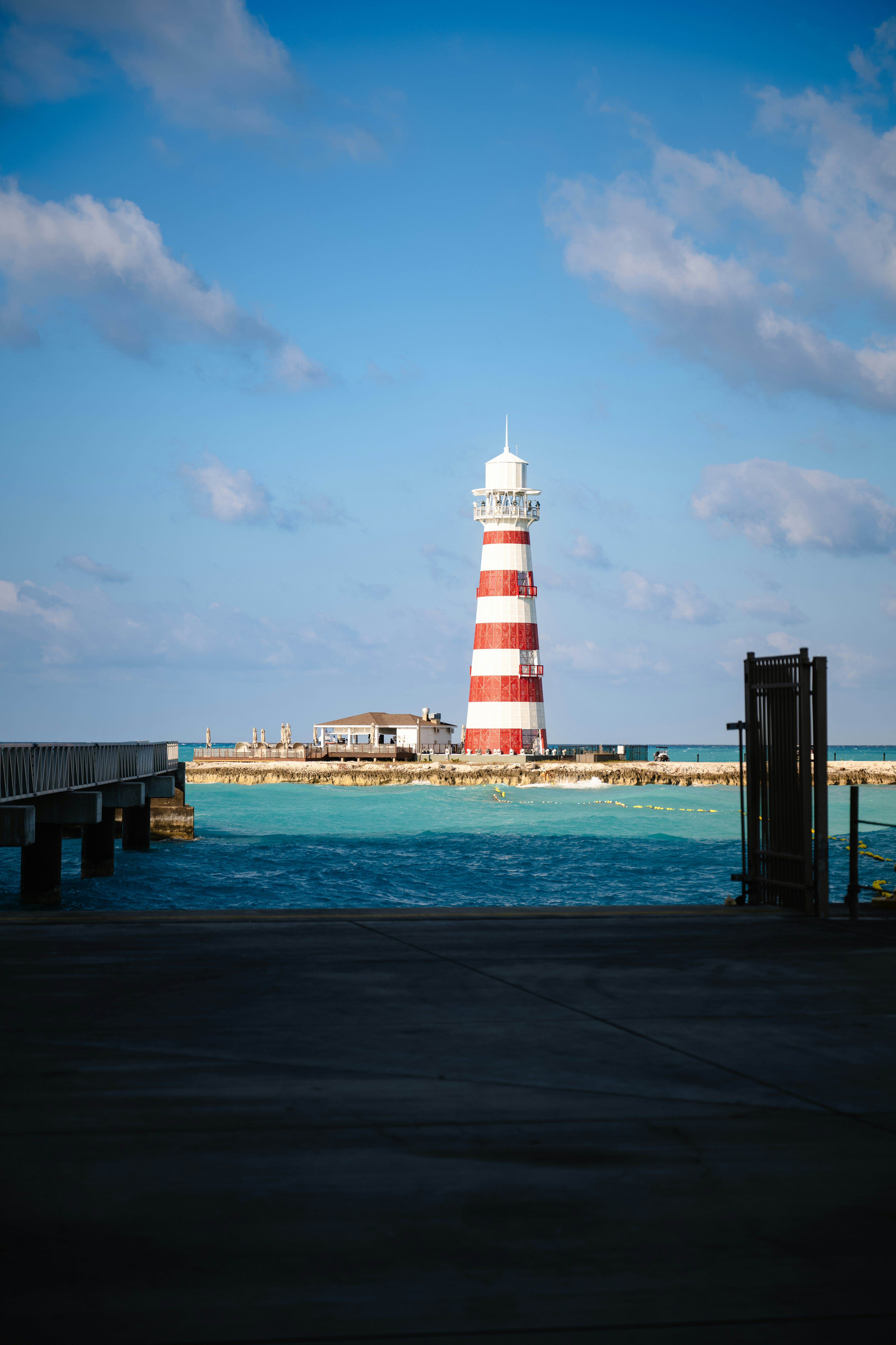 A red and white lighthouse sitting on top of a pier