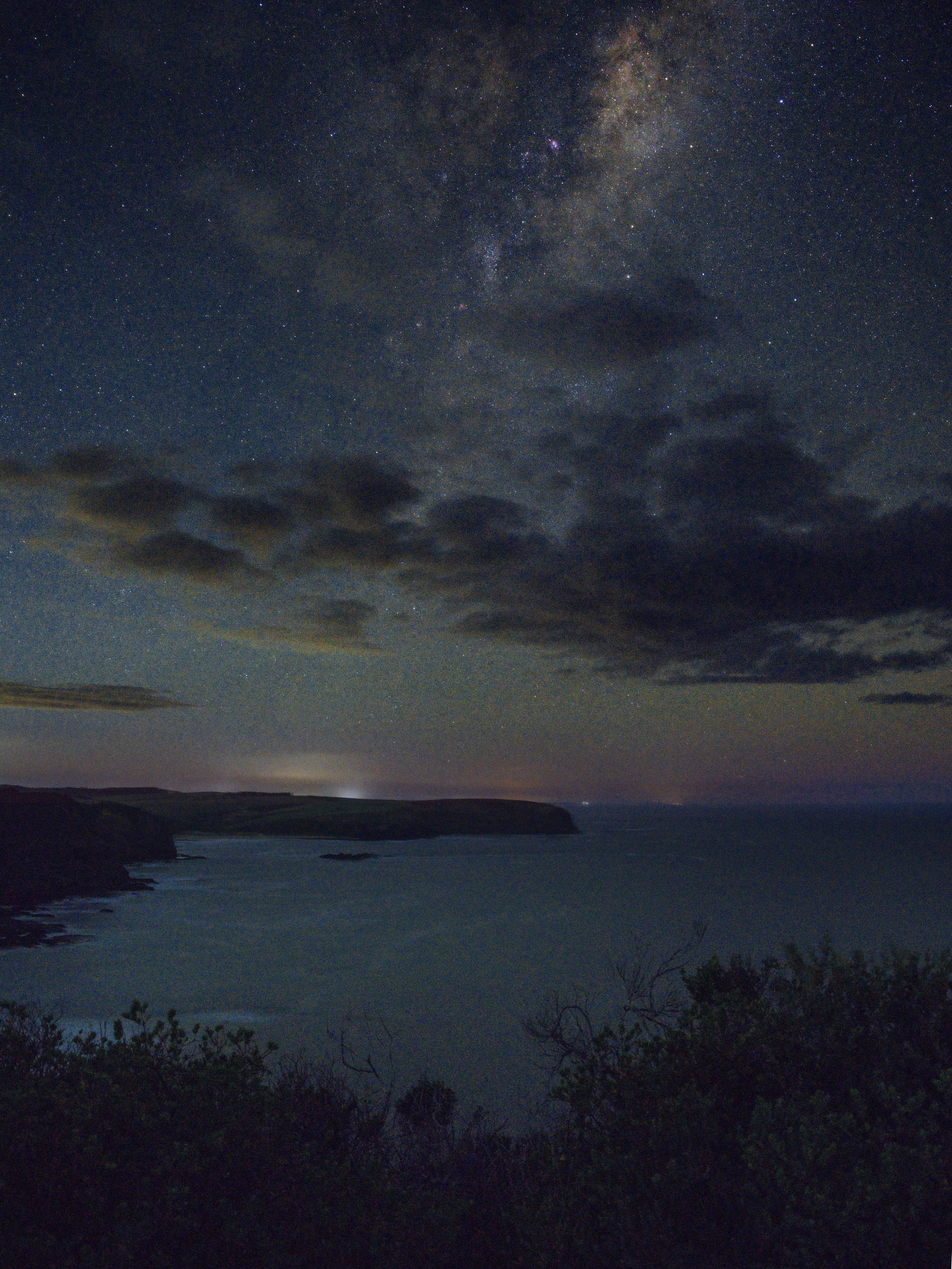 The night sky is filled with stars and clouds