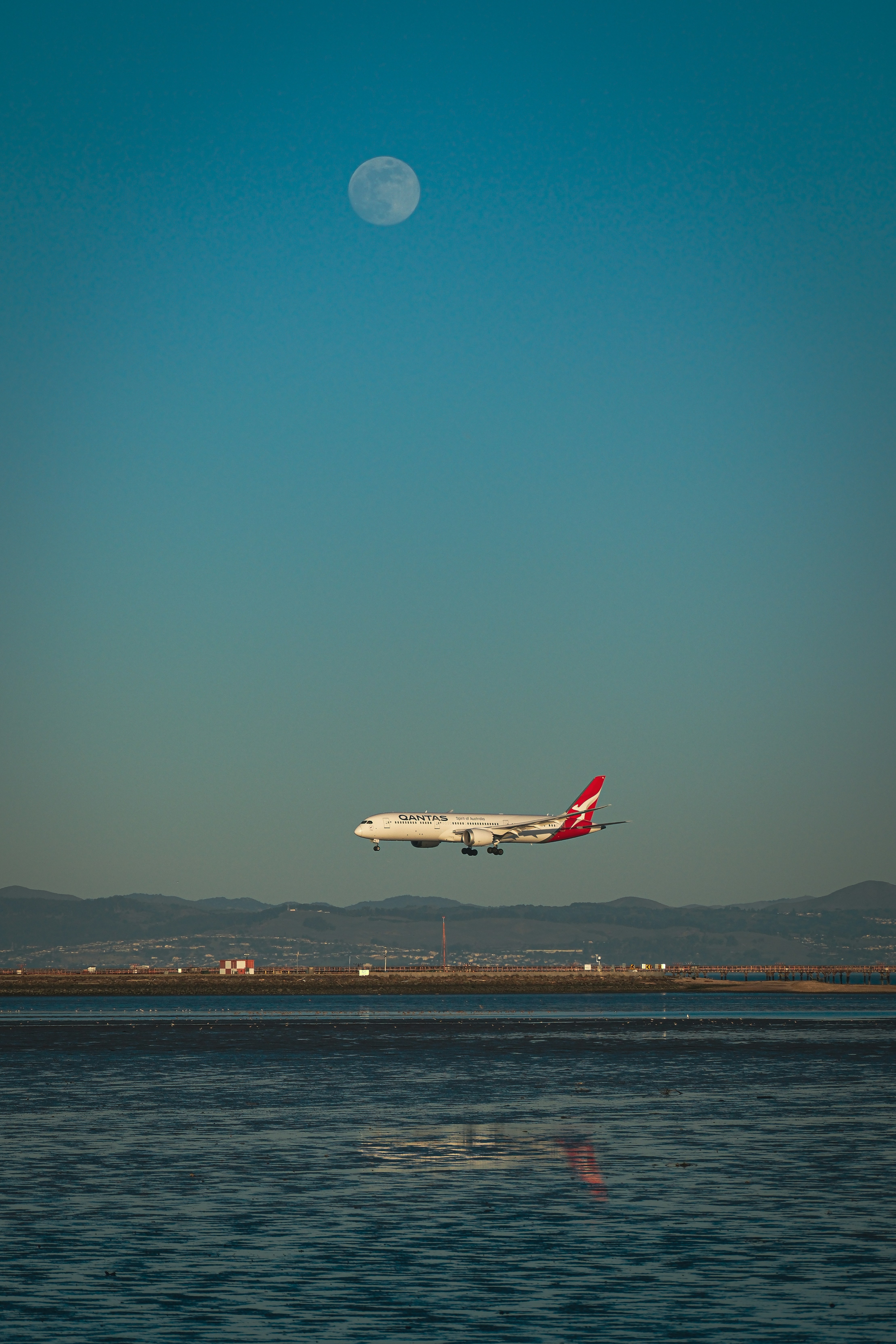 A large jetliner flying over a body of water photo – Free Aircraft ...