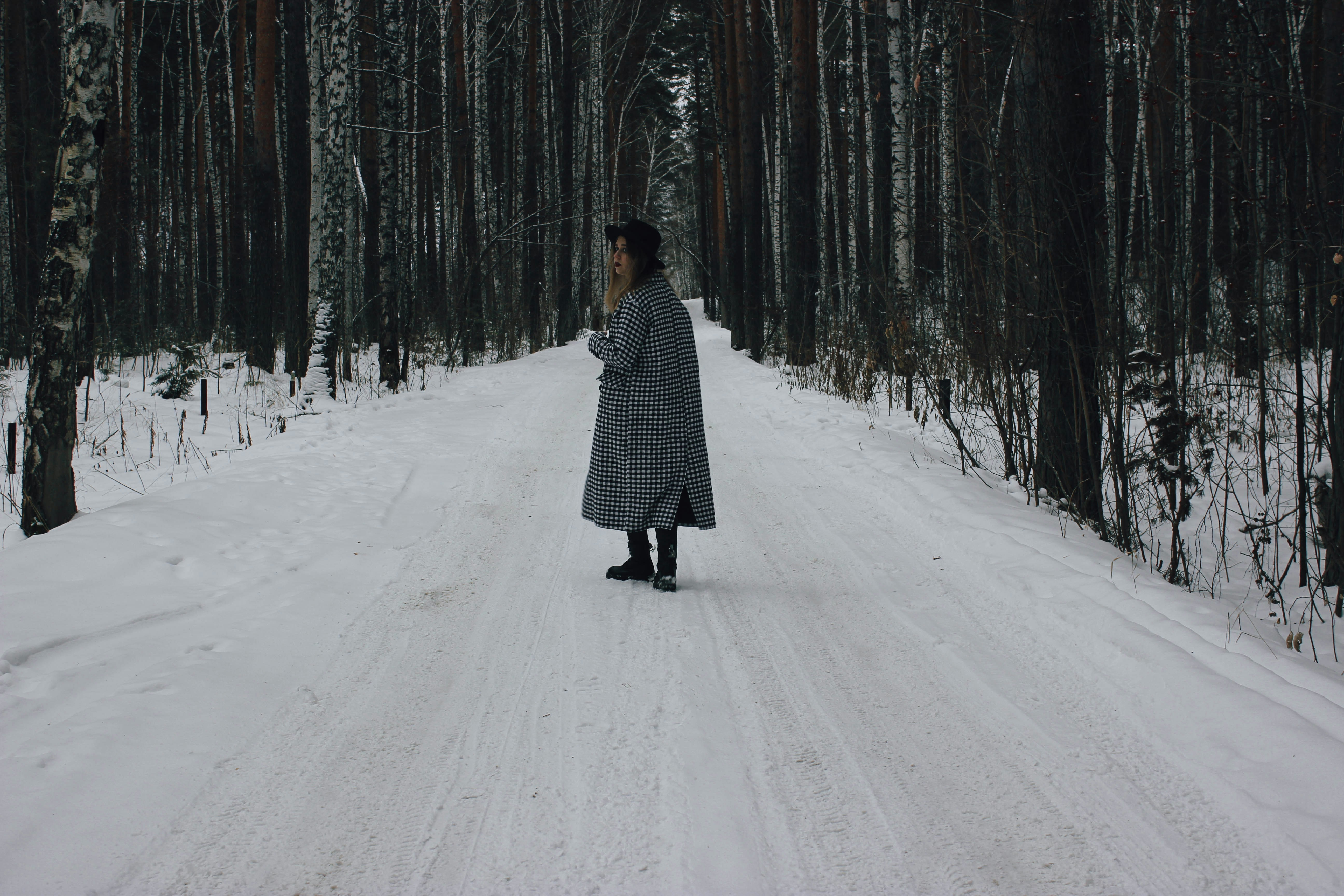 A woman walking down a snow covered road