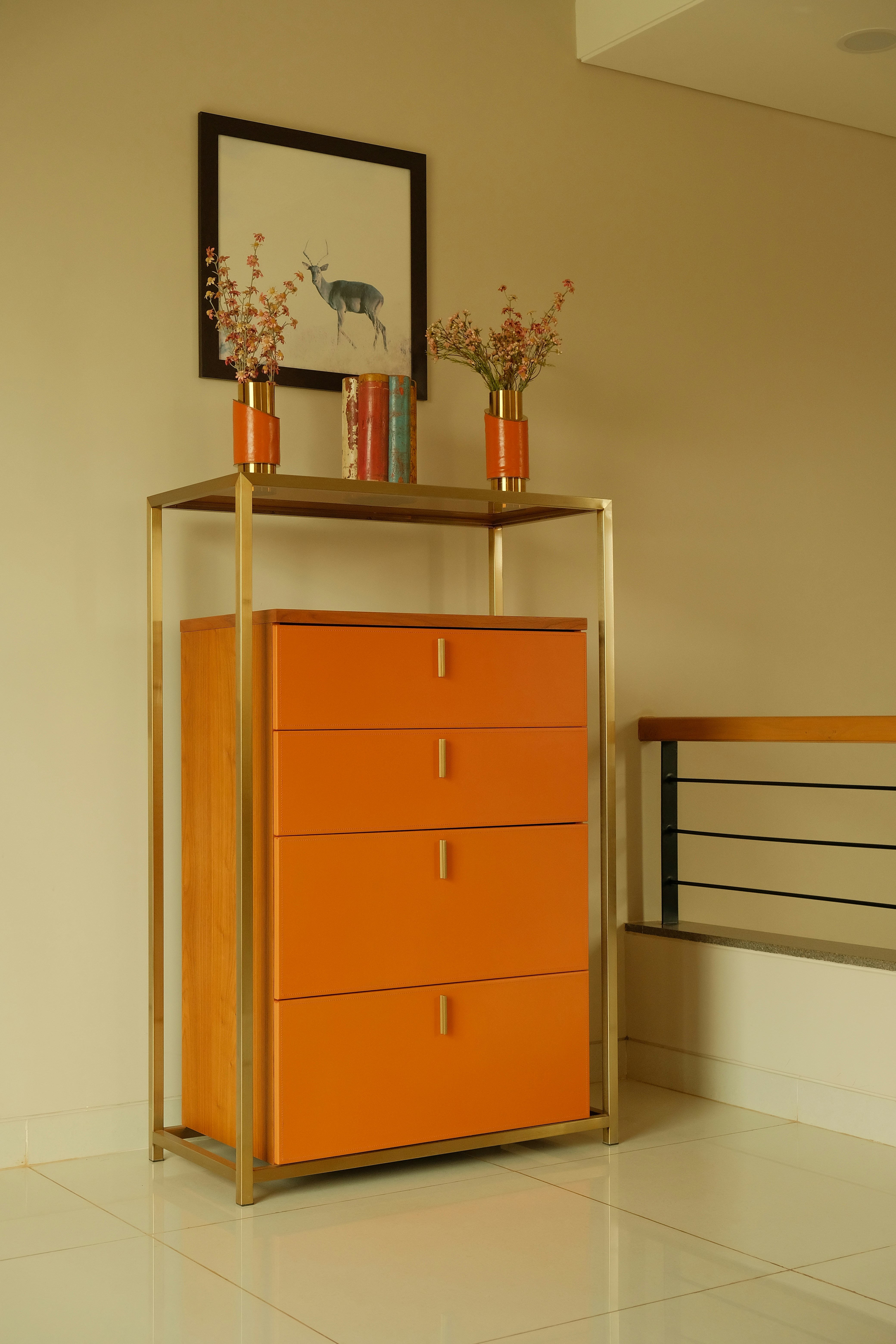 Eine orangefarbene Kommode in einem Raum mit einem Bild an der Wand