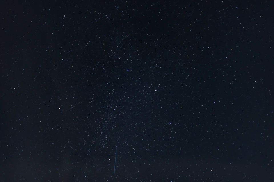 Multiple stars fill the night sky with scattered light against a dark background