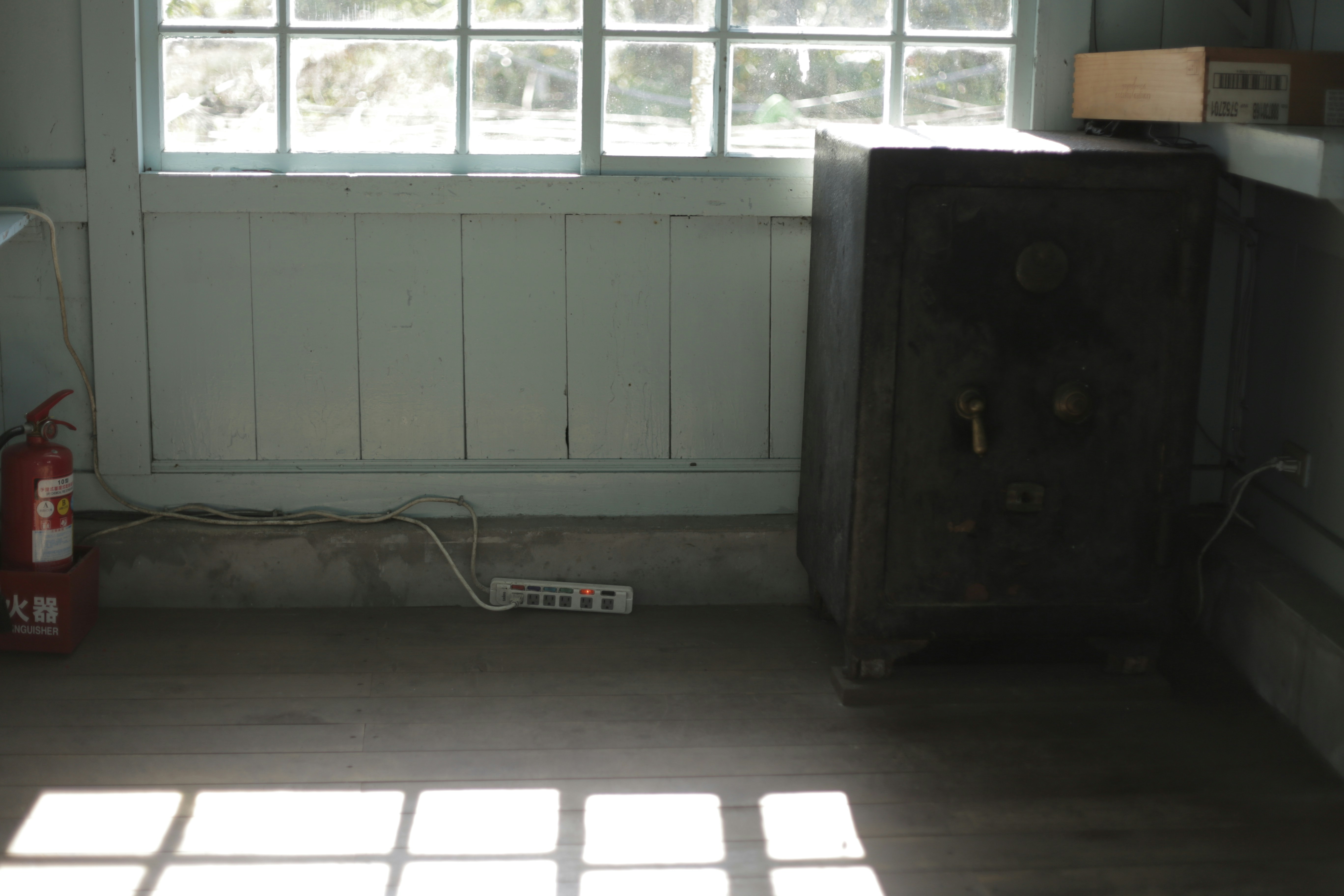 A room with a window, a cabinet, and a fire extinguisher