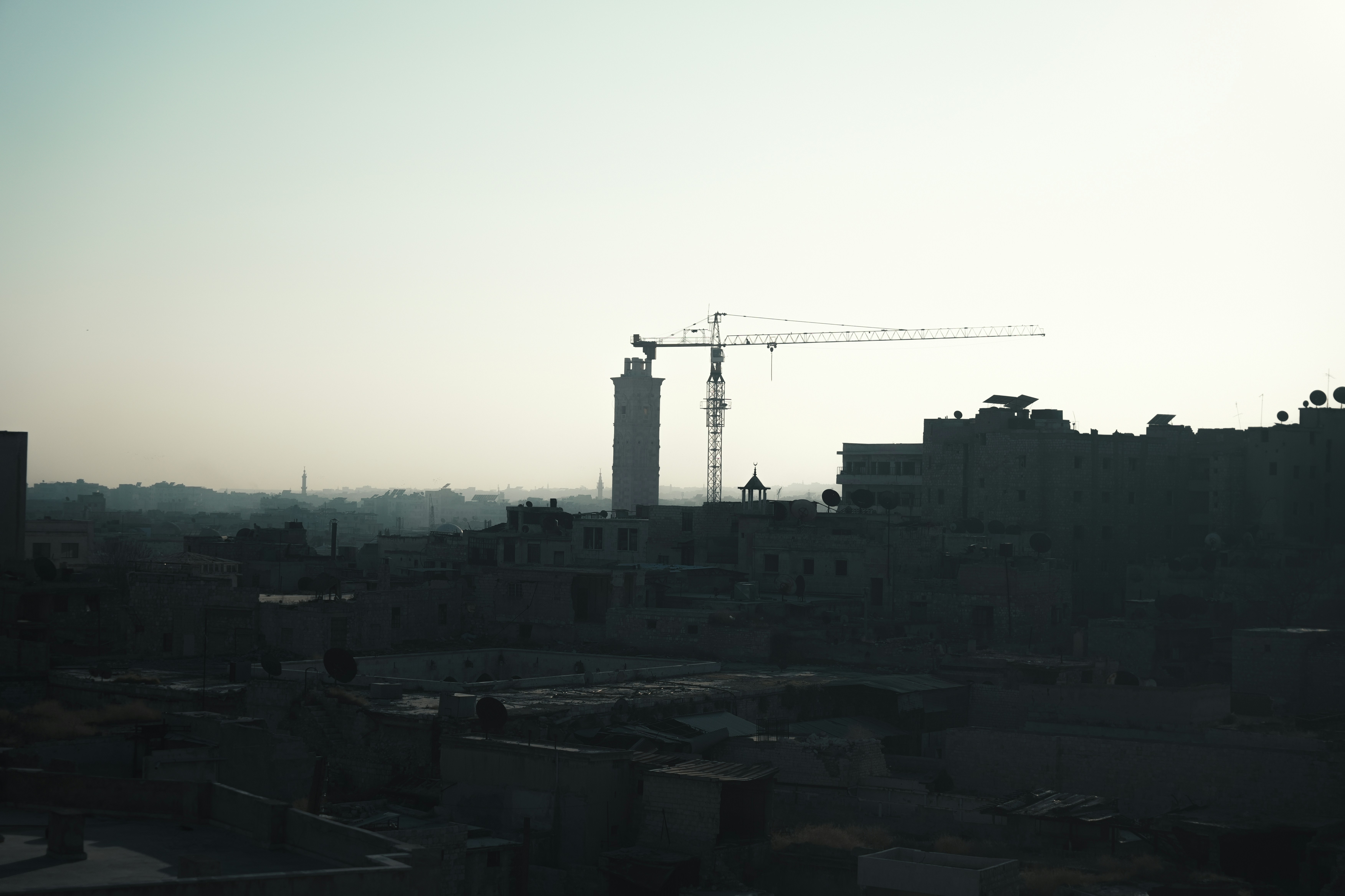 A view of a city with a crane in the background