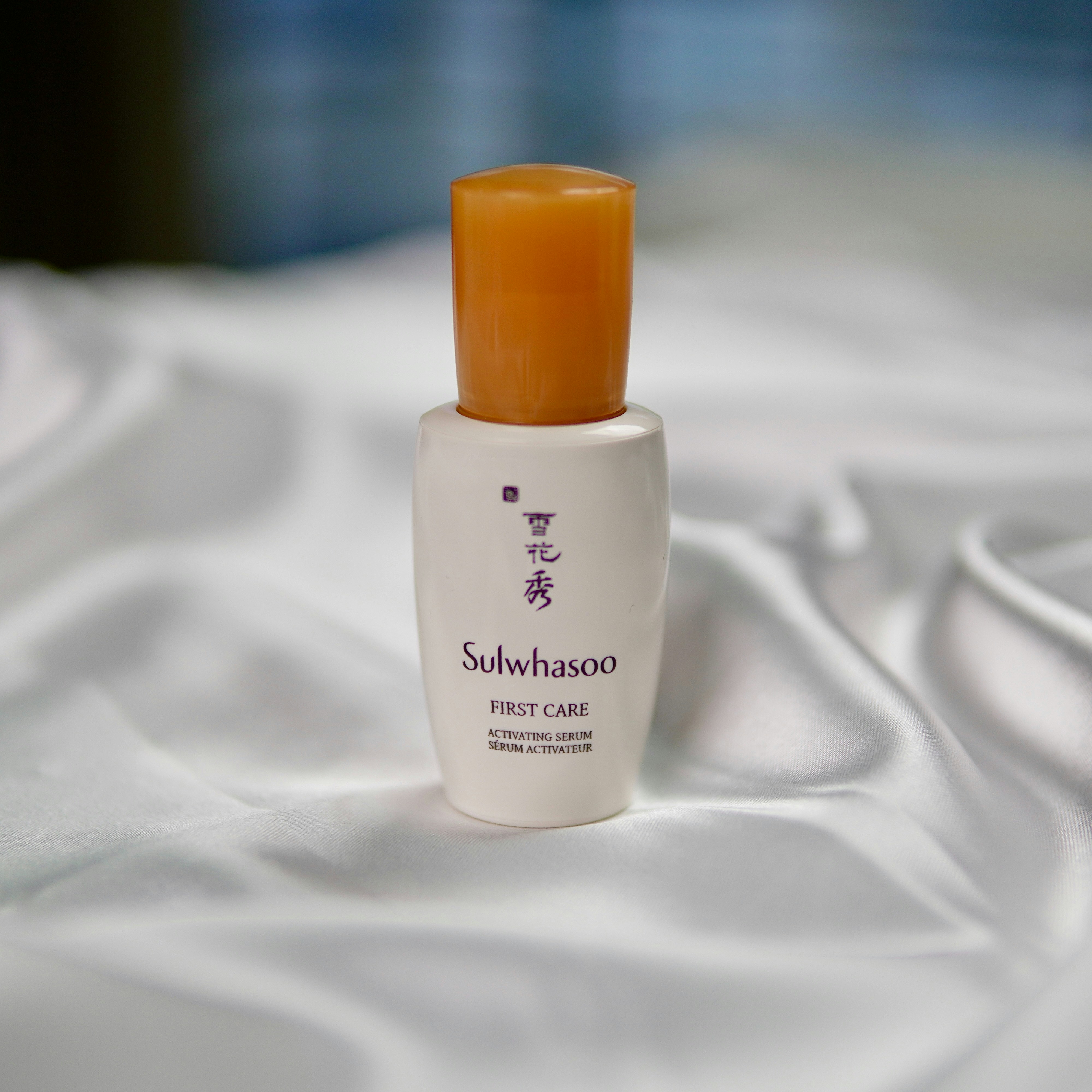 A bottle of skin care sitting on a bed