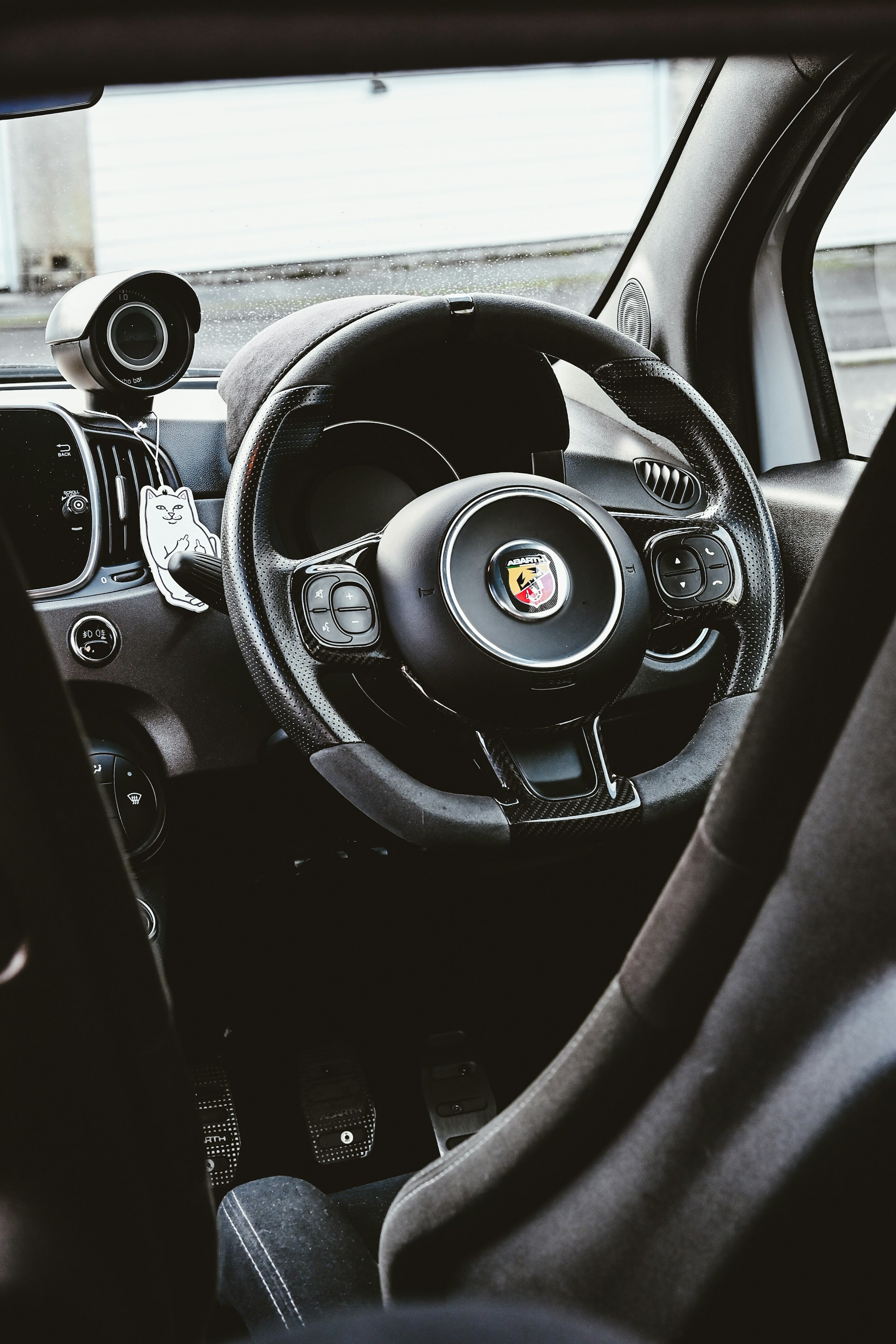 The interior of a car with a steering wheel and dashboard