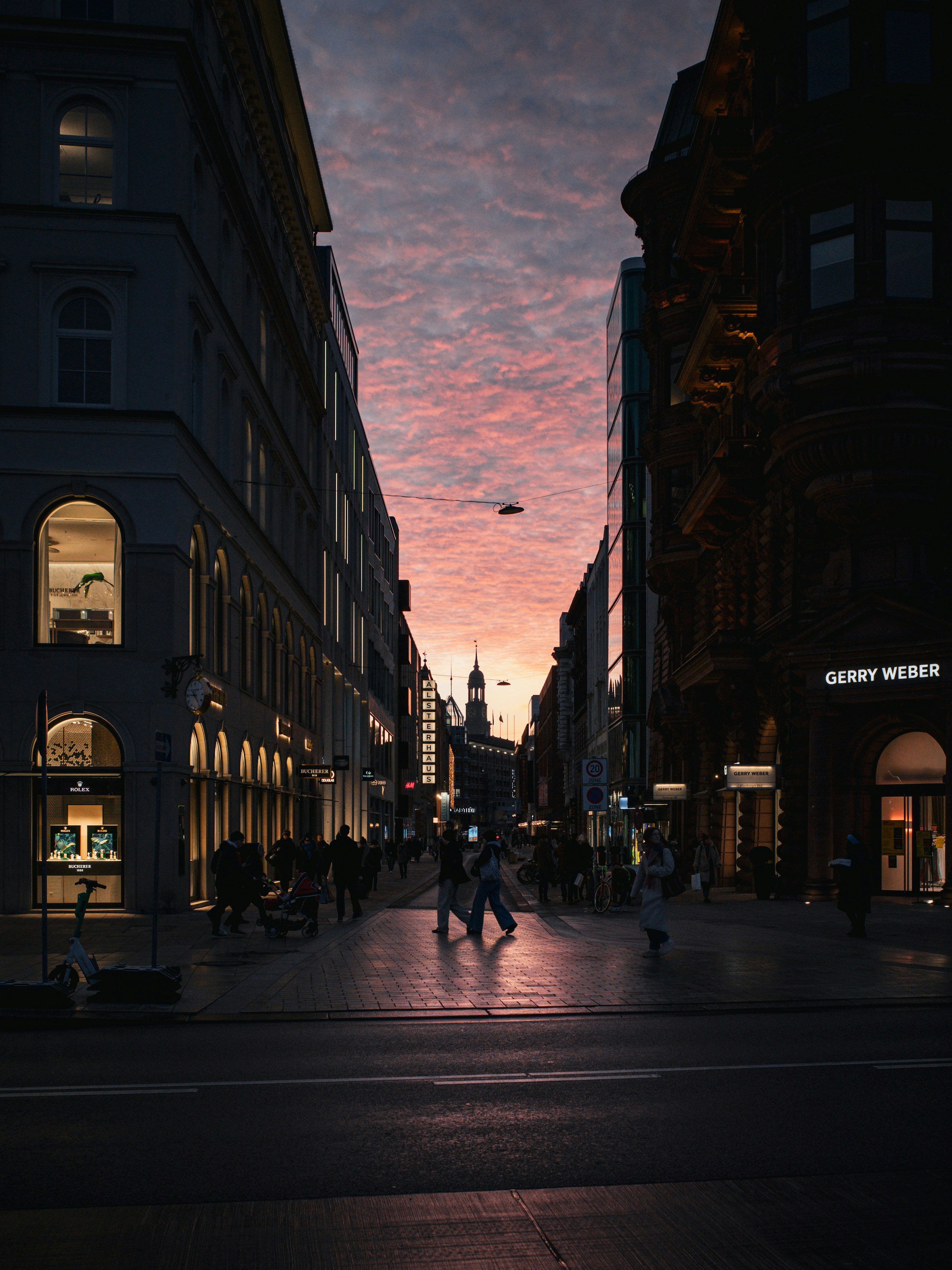 A city street at night with people walking on it