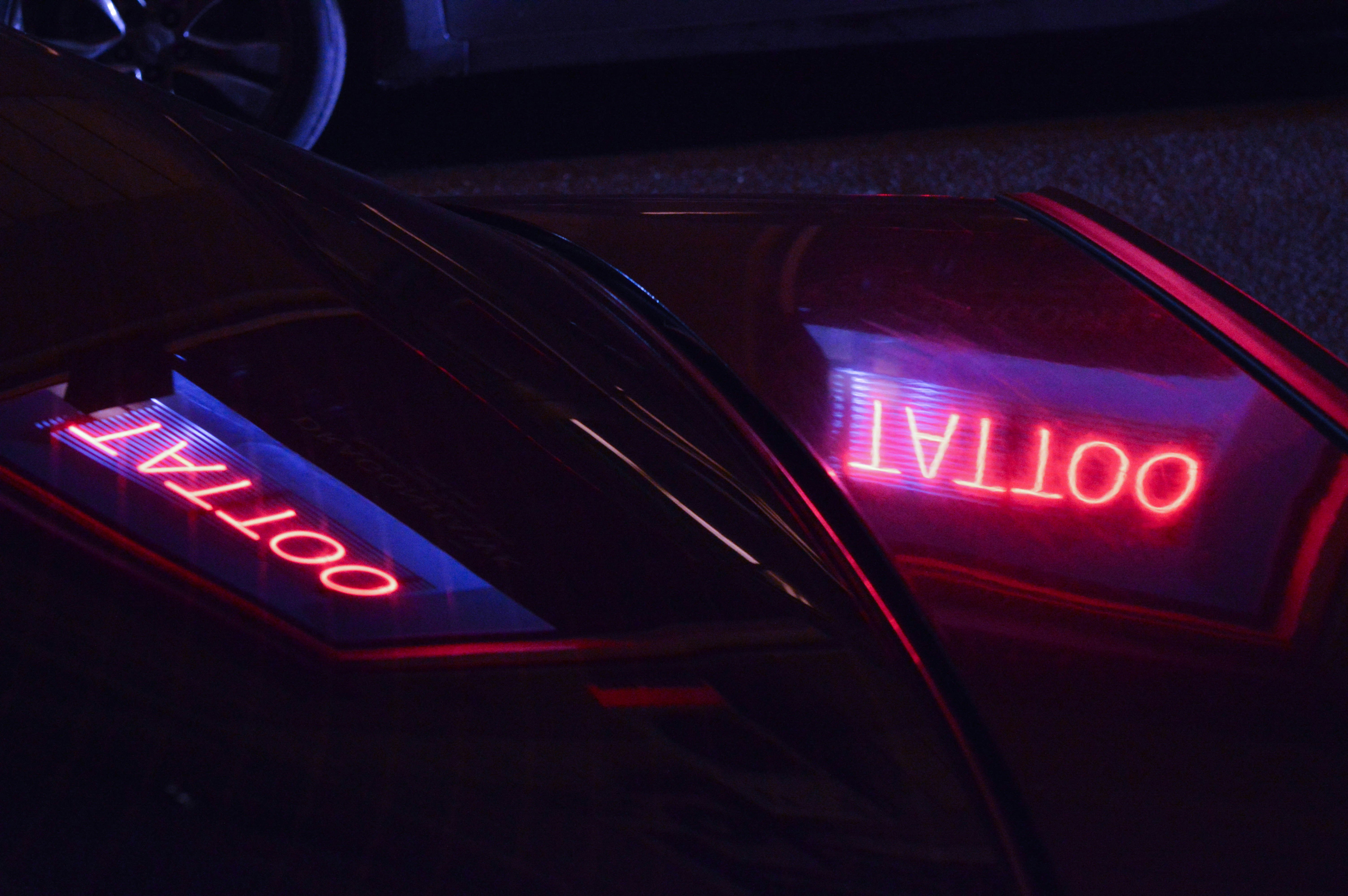 A close up of a car with a neon sign on it
