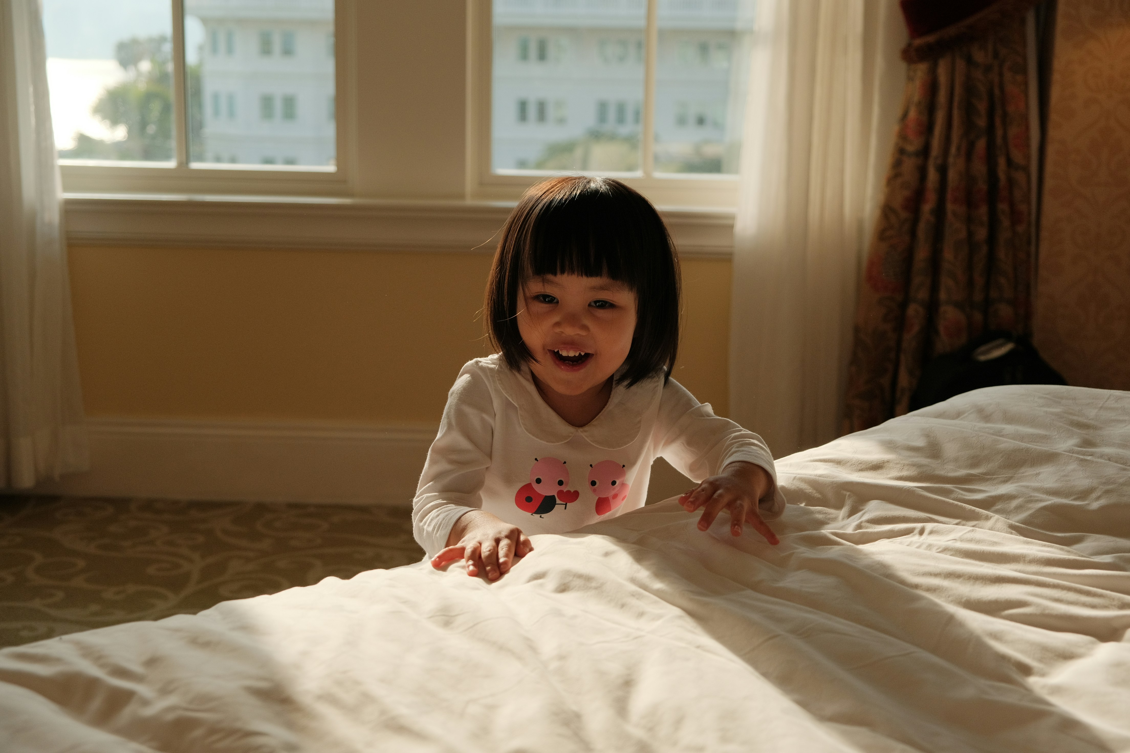 Una niña acostada en una cama en una habitación foto – Imagen de ...