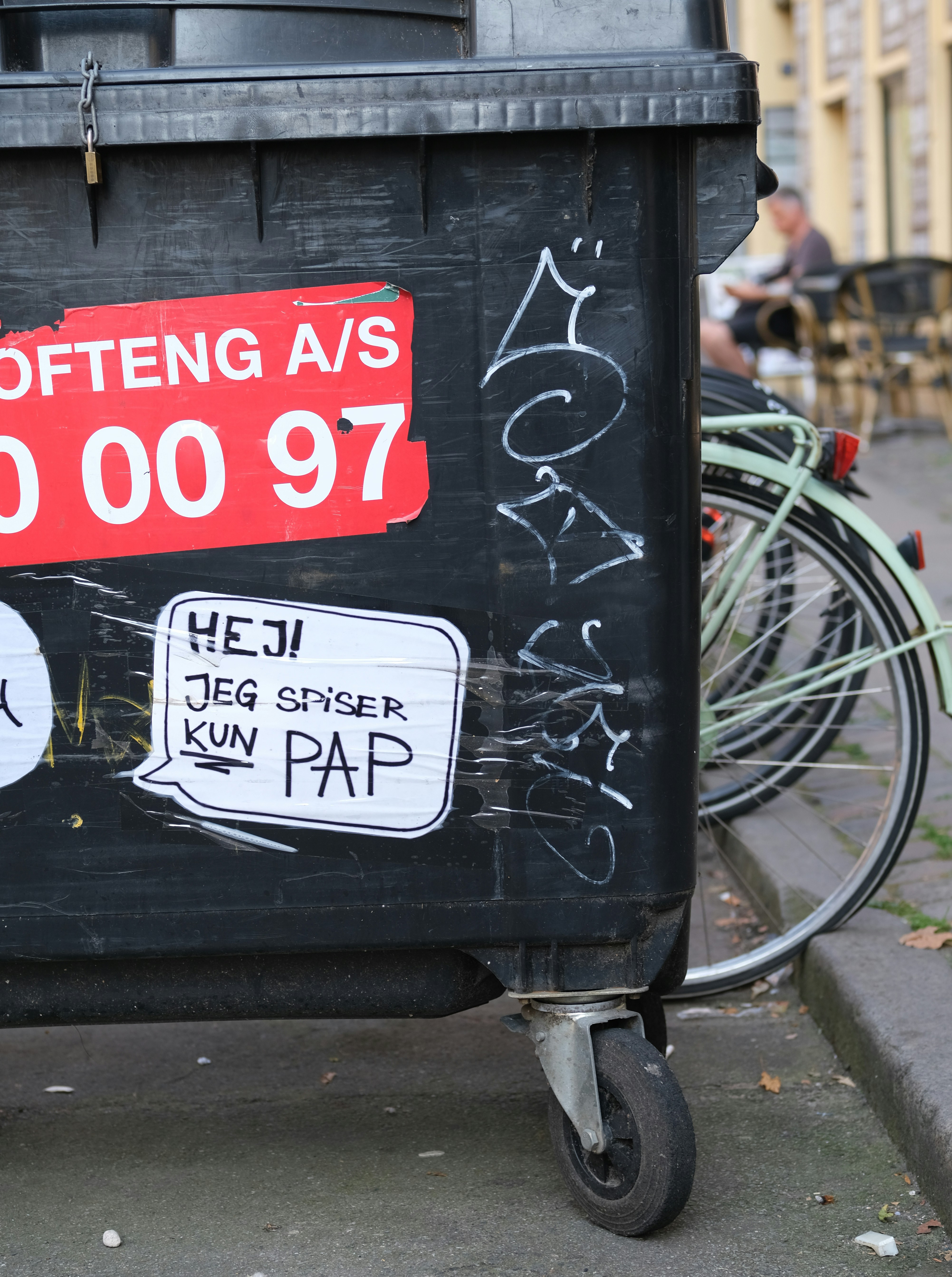 A black trash can with a red tag on it