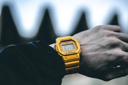 A close up of a person wearing a yellow watch