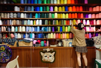 A person standing in front of a store filled with lots of colorful items