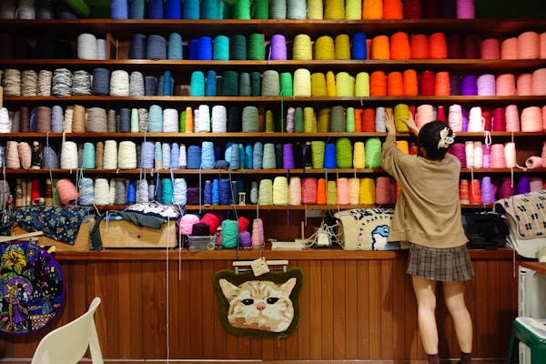 A person standing in front of a store filled with lots of colorful items