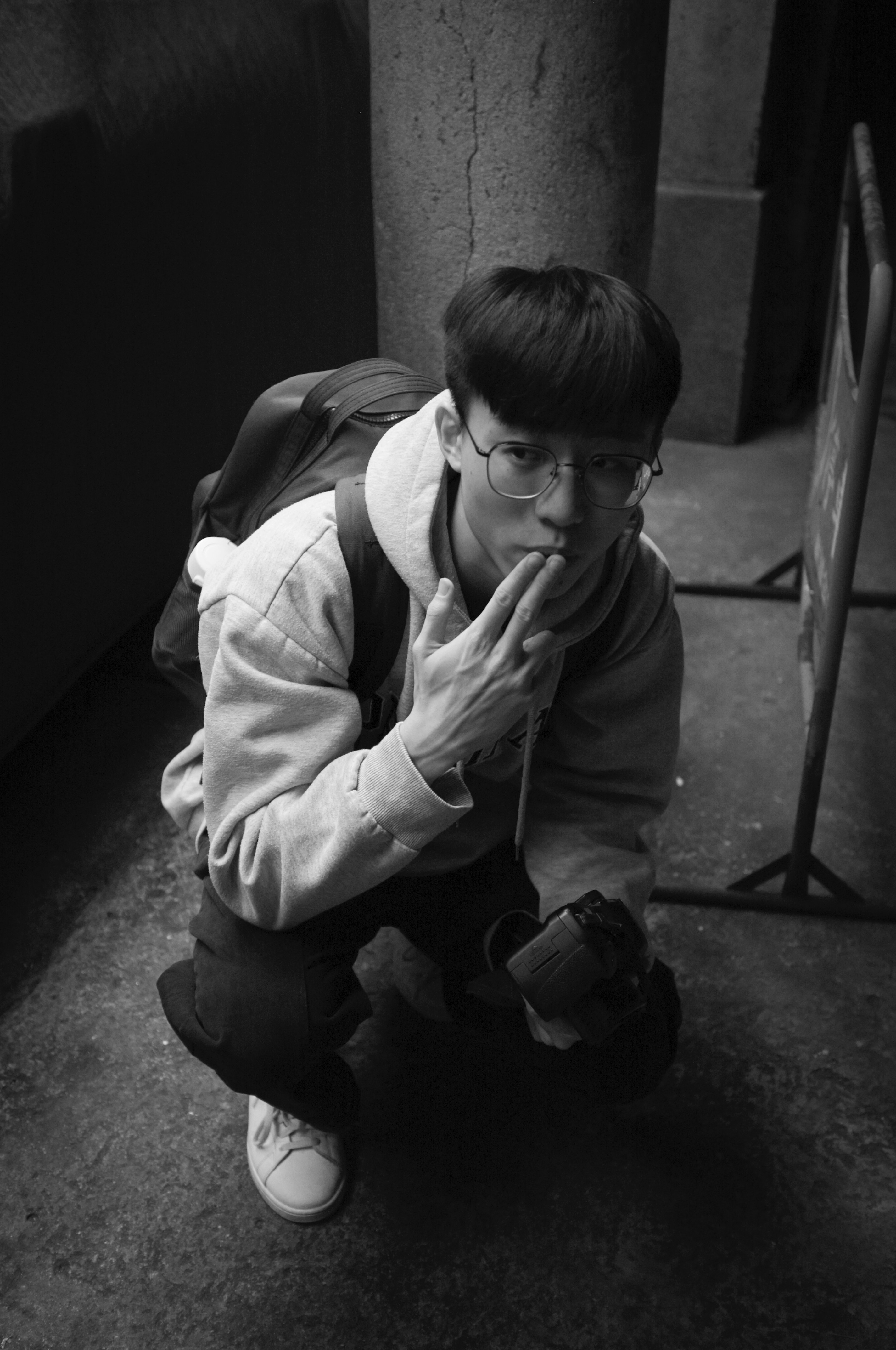 Un joven sentado en el suelo junto a una pared