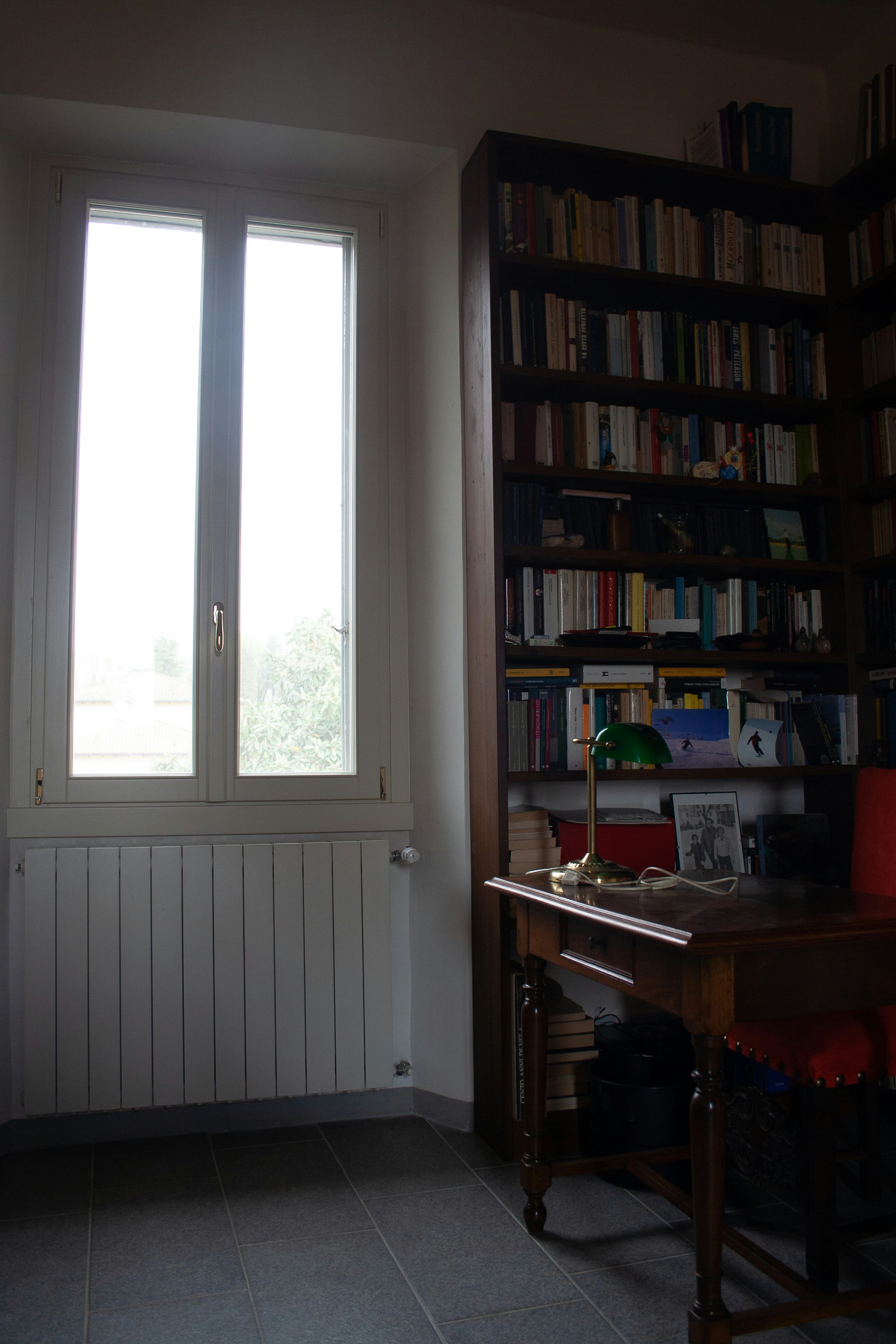 Home office with wooden bookshelves and a desk lamp.