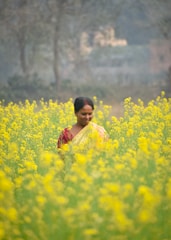 A woman standing in a field of yellow flowers