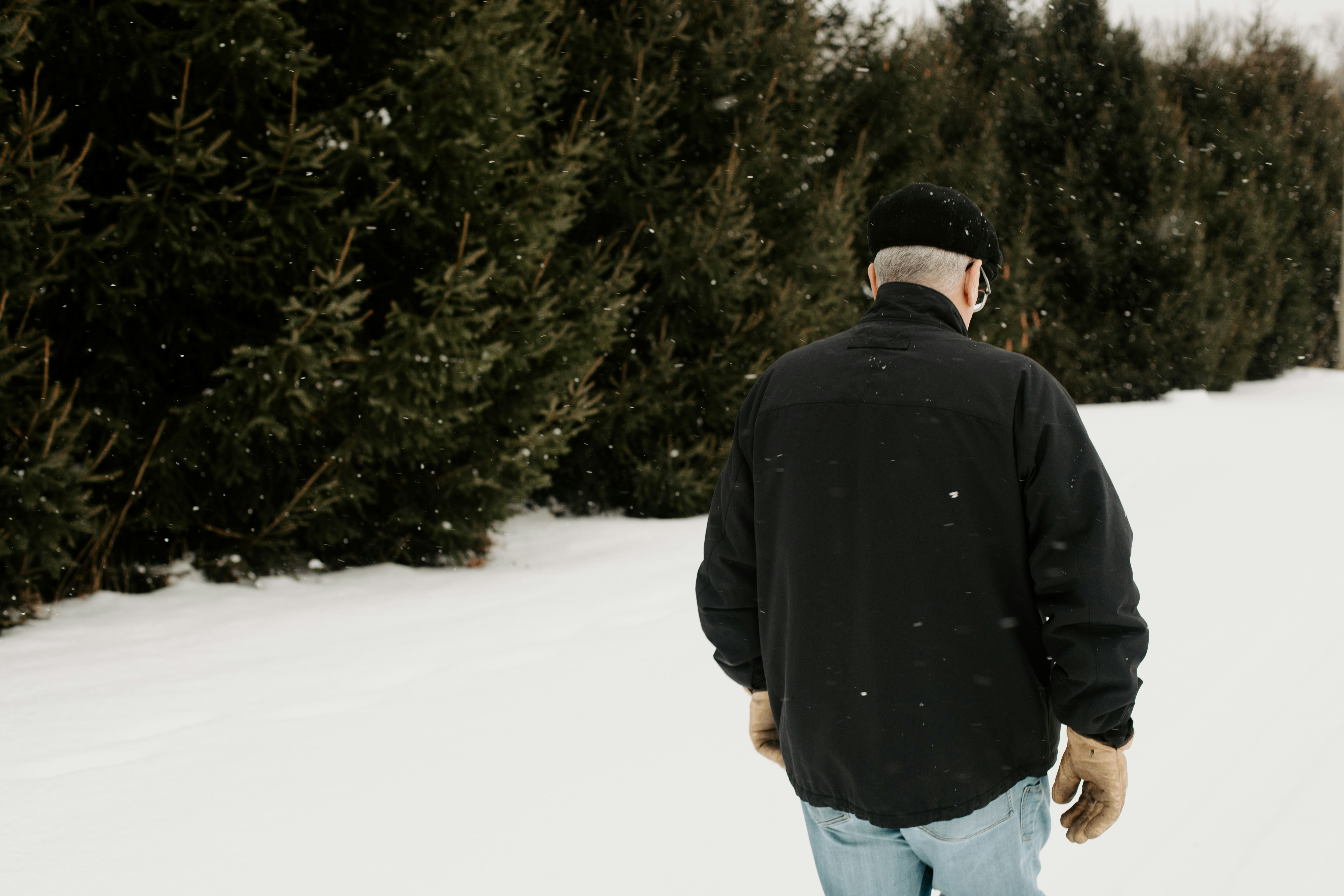 A man walking in the snow with a snowboard
