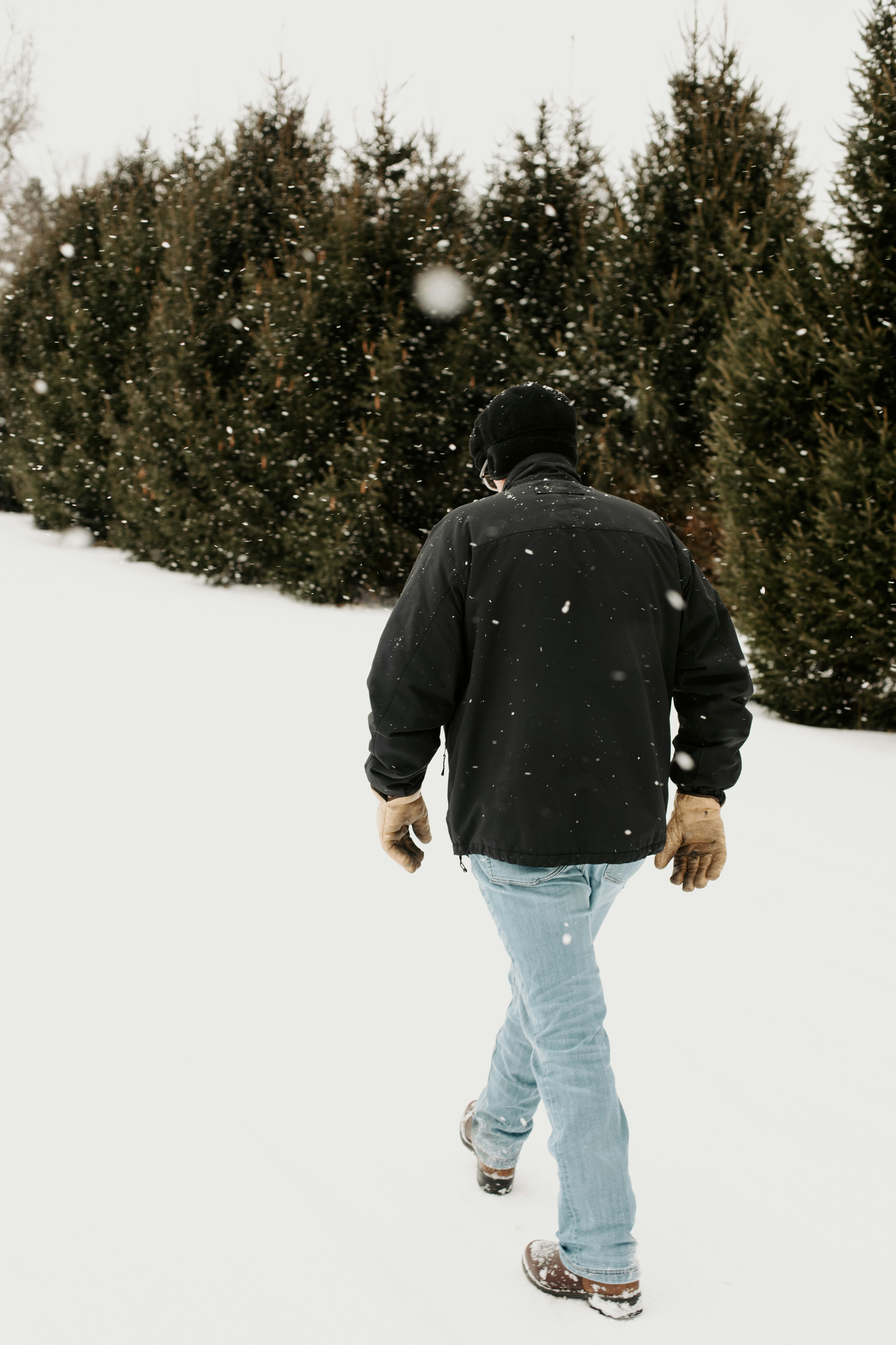 A person walking in the snow with a snowboard