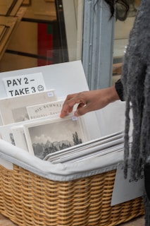 A person holding a newspaper in a wicker basket