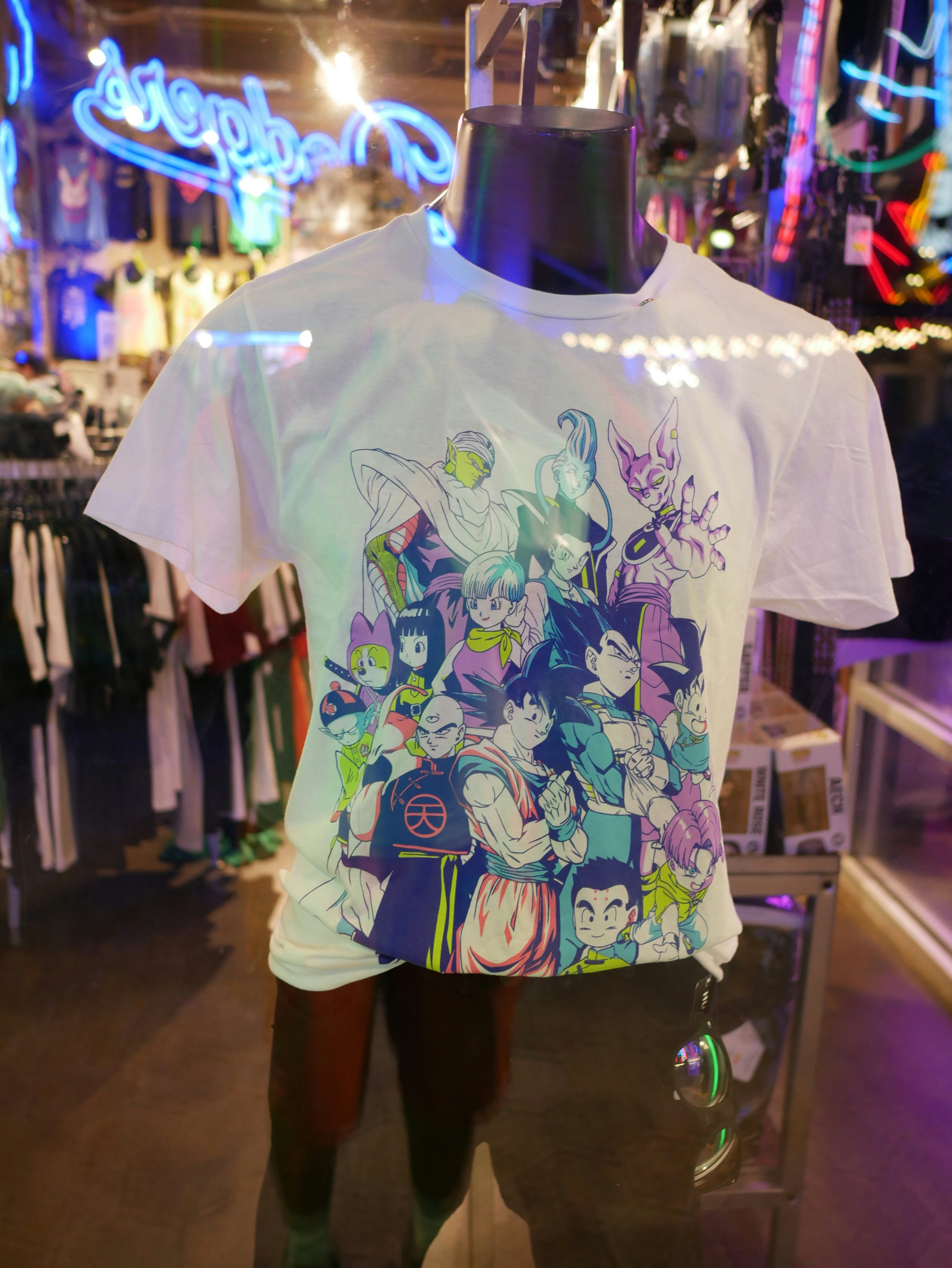 Graphic anime t-shirt displayed on a black mannequin in a window.