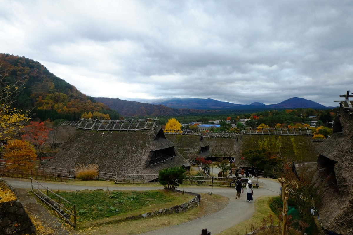 Scenic Japanese village nestled in mountains with autumn foliage, showing the type of rural area where akiya properties are found