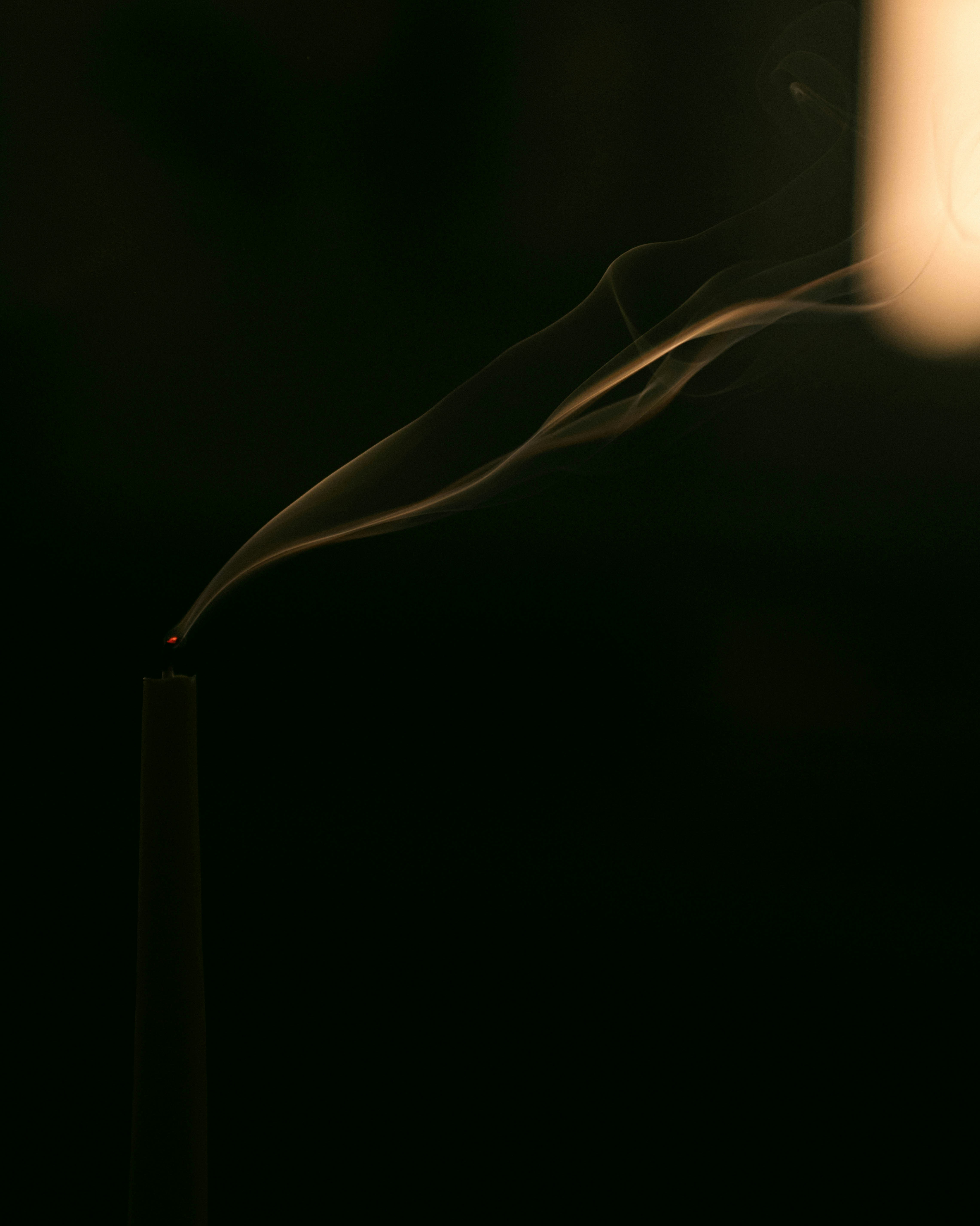 A lit candle with smoke coming out of it