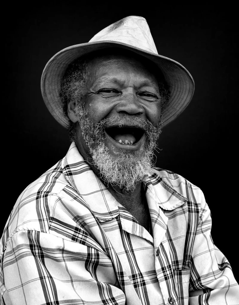 A smiling older man with short grey hair laughing warmly