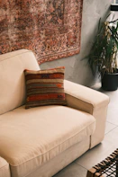 A living room with a couch and a rug on the wall