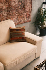 A living room with a couch and a rug on the wall