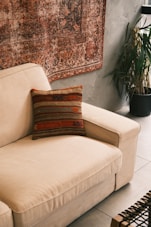 A living room with a couch and a rug on the wall