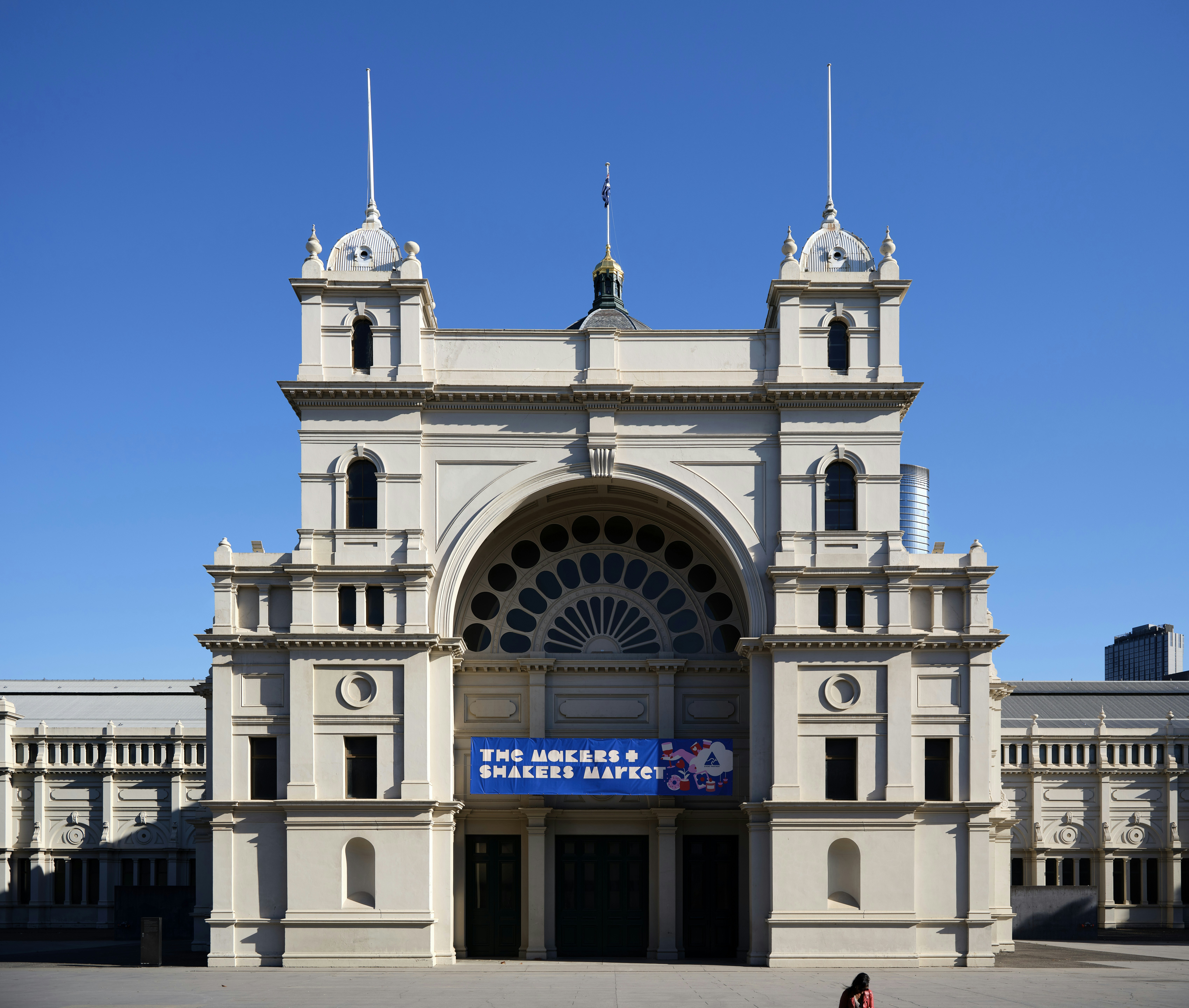 Una persona caminando frente a un gran edificio