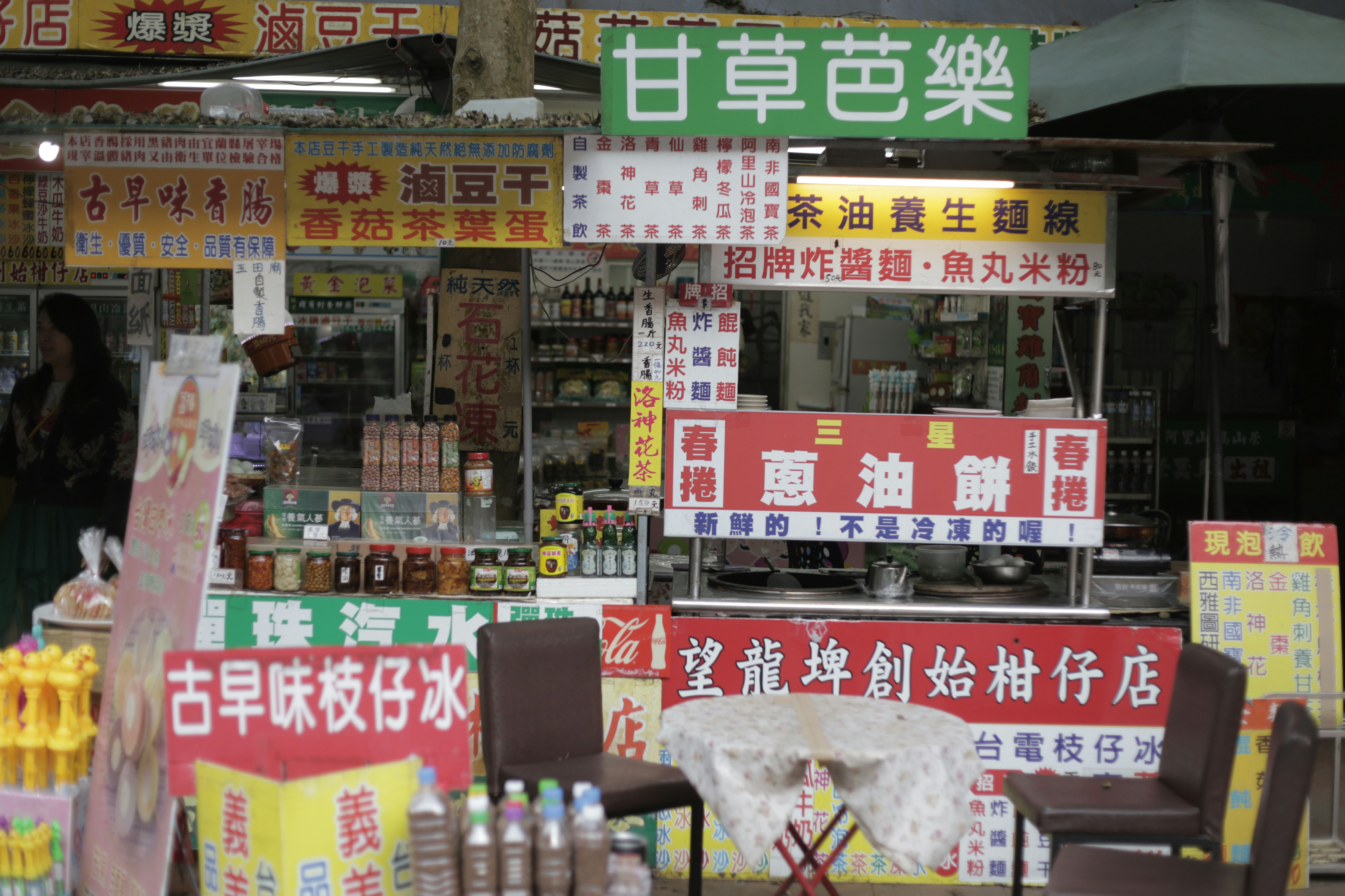A store with many signs and chairs in front of it