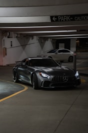 A car parked in a parking garage next to another car
