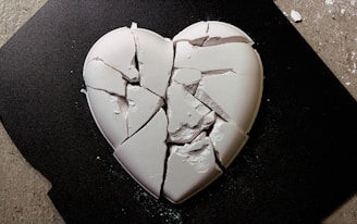 A broken heart shaped cookie sitting on top of a table