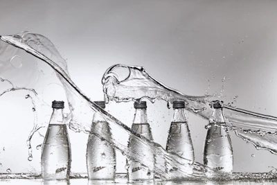 A group of bottles of water being filled with water