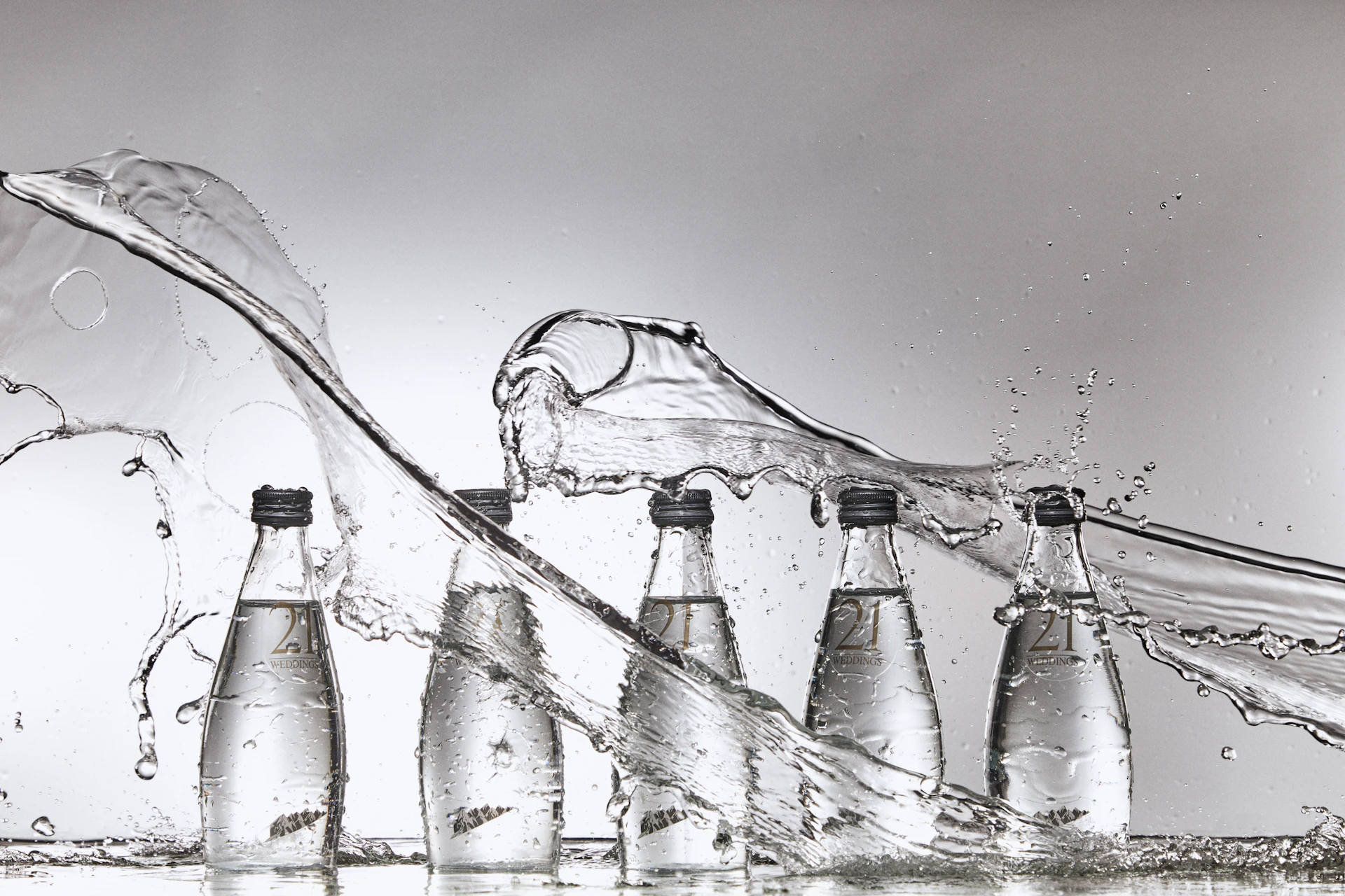 A group of bottles of water being filled with water