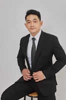 A man in a suit sitting on a stool