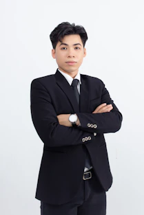 A man in a suit and tie standing with his arms crossed