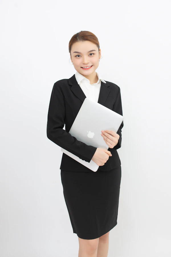 Woman in a business suit holding a laptop