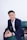 A man in a suit sitting on a green couch
