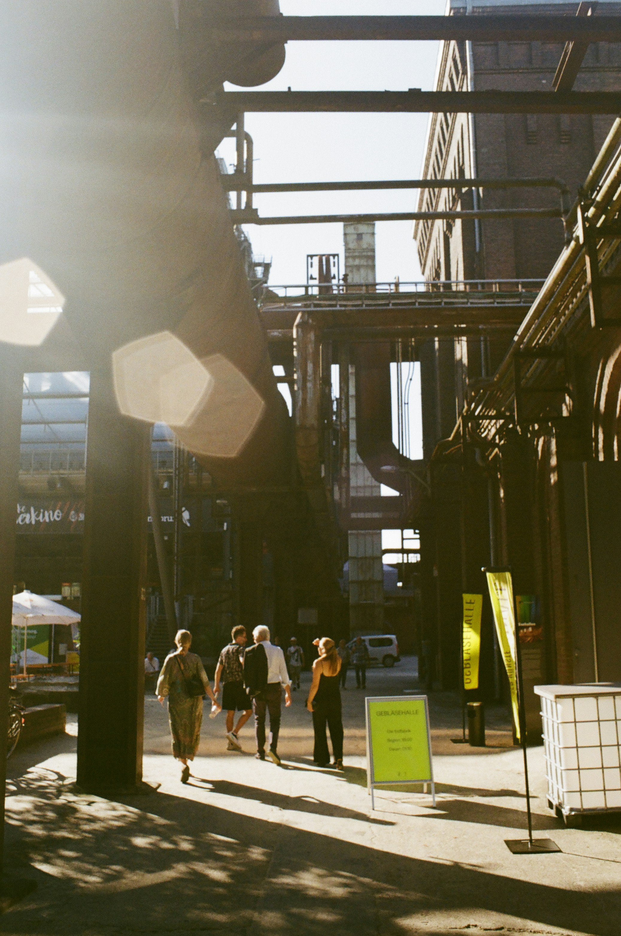 A group of people walking down a street next to tall buildings