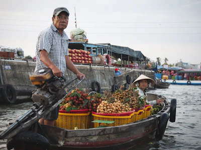 A man in a boat filled with lots of fruit