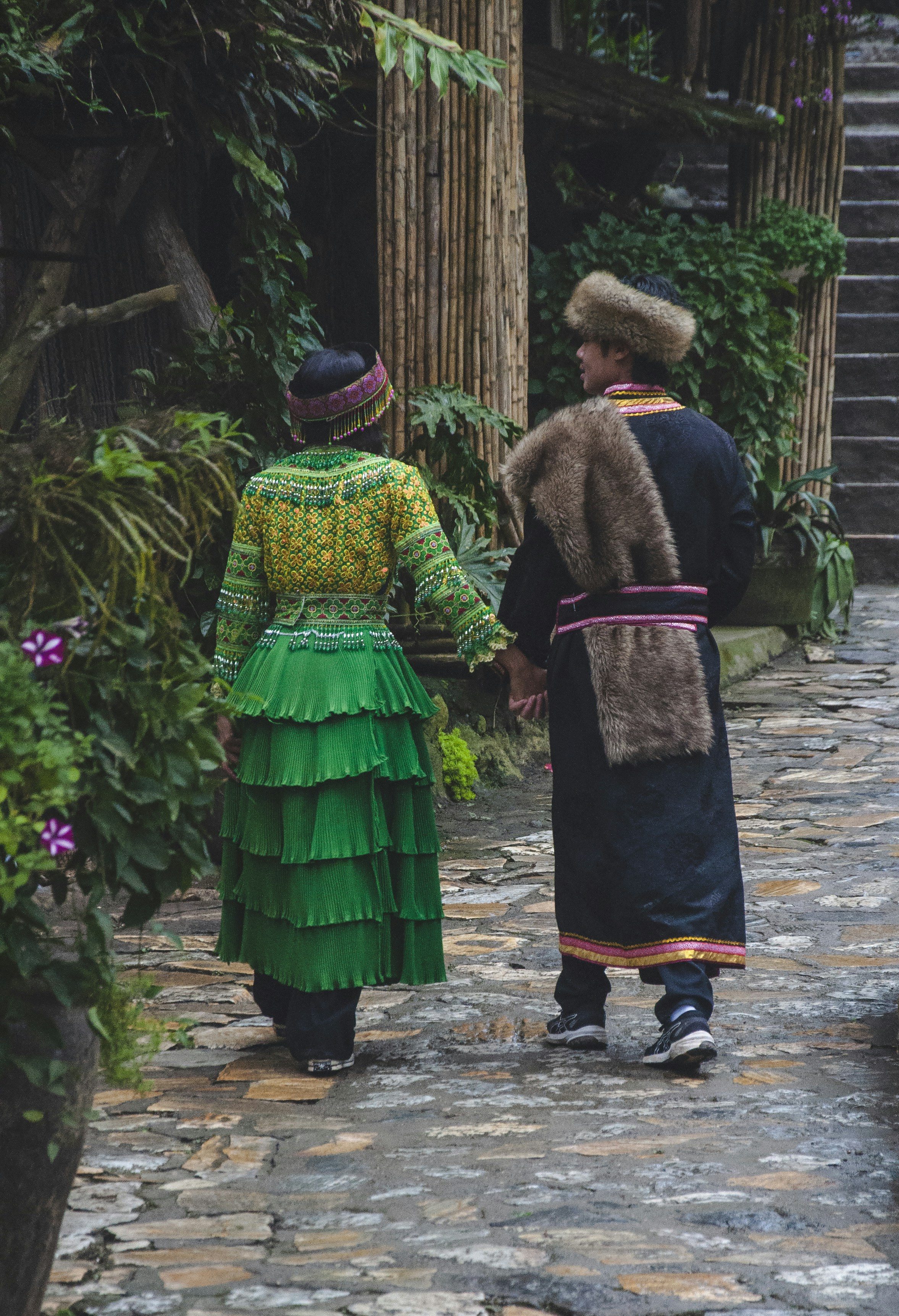 A couple of people walking down a stone road